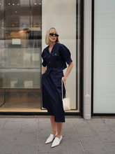 a lady in a denim v-neck top and a denim midi skirt